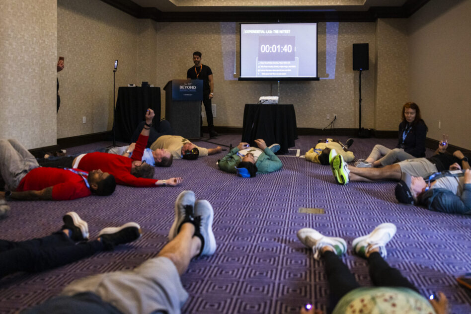 Attendees lying on the floor doing breathwork.